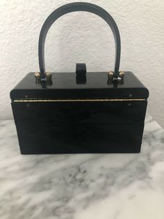 Vintage Maxim Black Acrylic Handbag 1950’s. Shipped with USPS Priority Mail. Black acrylic with gold tone hardware . Mirror shows age and there are surface scratches. Has 2 separate compartments ... top one opens & has the mirror. Then the next one slides up & out so you have 2 levels. Very cute bag . 7 x 3”. 4.25” to top of box & 9” to top of handle Retro Rectangular Box Bag For Evenings, Retro Rectangular Evening Box Bag, Vintage Rectangular Box Bag For Party, Vintage Rectangular Bags For Vintage Events, Vintage Box Bag With Detachable Handle For Evening, Vintage Evening Box Bag With Detachable Handle, Vintage Rectangular Bags For Events, Vintage Top Handle Evening Bag For Formal Occasions, Vintage Formal Evening Bag With Top Handle