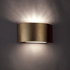 a wall mounted light that is on the side of a wall with white walls behind it