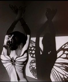 two women in black and white are dancing with their hands up to the ceiling,