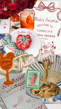 an assortment of food and drink items are displayed on a table with cards, paper fans, and flowers