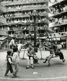 children playing on a swing set in an urban area