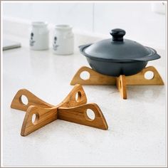 two pieces of wood sitting on top of a counter next to a pot and pan