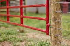 a red fence is next to a wooden post