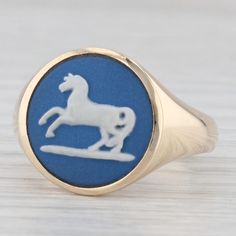 This lovely vintage wedgewood ring is features a signet style bearing a horse done in the classic wedgewood blue and white. The ring comes with a Liberty of London inner and outer box, both is great condition. This piece has a retail value of $840 so don't pass up this great deal!  Material: - Wedgewood Cameo - Size - 14.5 mm Cut - Round Color - Blue and White Metal: 9k Yellow Gold Weight: 6.6 Grams  Stamps: 375, other British hallmarks Face Height: 15 mm  Rise Above Finger: 4.5 mm Band / Shank Width: 3.3 mm This ring is a size 7 1/2, but it can be resized up 2 sizes for a $30 fee per size. If you would like your ring resized, please select the appropriate fee from the listing below in order to pay the sizing fee: https://www.etsy.com/listing/781388346/ring-sizing-service-fee Each piece is Vintage Blue Signet Ring For Formal Occasions, Vintage Blue Signet Ring, Classic Blue Signet Ring For Wedding, Classic Blue Signet Ring Stamped 14k, Classic Cameo Rings, Blue Antique Signet Ring For Formal Occasions, Antique Blue Hallmarked Signet Ring, Classic Blue Hallmarked Signet Ring, Classic Hallmarked Blue Signet Ring