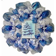 a blue and white christmas wreath with an ornament in the center on a white background