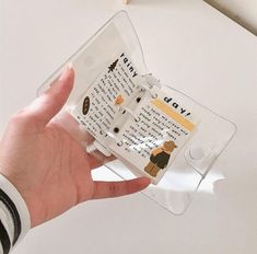 a person is holding up a clear case with some writing on the inside of it