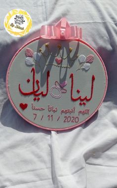 a pink ribbon is attached to the back of a sign that reads, love you in arabic