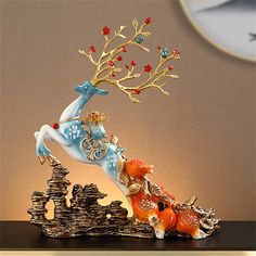 a figurine of a deer with red berries on its antlers is shown in front of a clock