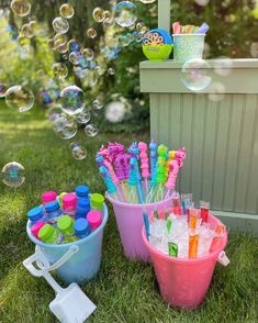 several buckets filled with lots of different colored toothbrushes and soapy bubbles