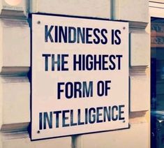 a sign that says kindness is the highest form of inteliligence in front of a building