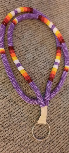 a purple lanyard with an orange, yellow and white stripe on it