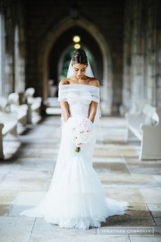 a woman in a white wedding dress is posing for the camera