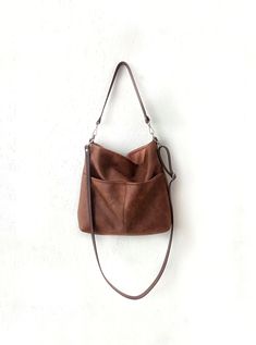 Large hobo style bag The bag is made of high quality faux leather in distressed cognac brown color. It is fully lined with cotton fabric in light brown color. * Large front pockets * two inner slip pockets perfect for phone, keys, cardholder etc. *closes with magnetic snap button *the shoulder strap and the crossbody strap (if added) are made of thick cowhide leather for extra support * additional crossbody strap can be added (please choose the option from the dropdown menu) *silver tone hardwar Brown Leather Hobo Handbags, Brown Large Capacity Hobo Crossbody Bag, Everyday Brown Hobo Bag With Double Handle, Brown Double Handle Hobo Bag For Everyday, Everyday Large Capacity Brown Hobo Bag, Brown Double Handle Hobo Bag, Vintage Brown Bag With Removable Pouch For Everyday Use, Vintage Brown Bag With Adjustable Strap For Everyday, Brown Hobo Shoulder Bag For On-the-go