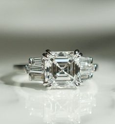 an emerald cut diamond ring with baguettes on the side