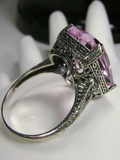 Simulated Pink Topaz Ring G Design#5 Custom Made Inspired by Edwardian era and Art Deco designs, I now offer this lovely filigree reproduction in sterling silver. This is a flawless Man-made/Simulated pink topaz is 15mm (5/8th of an inch) by 12mm (1/2 inch) in size. The inside of the band is etched 925. Notice the intricate and detailed design of the antique silver filigree setting all the way down the band. This is an exquisite rendition of an antique filigree ring.... and is ready to wear. A g Vintage Emerald Cut Amethyst Ring Gift, Vintage Amethyst Ring With Accent Stones For Collectors, Vintage Amethyst Ring With Accent Stones, Vintage Topaz Ring With Accent Stones Gift, Antique Hallmarked Amethyst Wedding Ring, Antique Silver Topaz Ring Collectible, Antique Silver Topaz Collectible Ring, Victorian Amethyst Ring With Prong Setting, Victorian Hallmarked Topaz Ring For Wedding