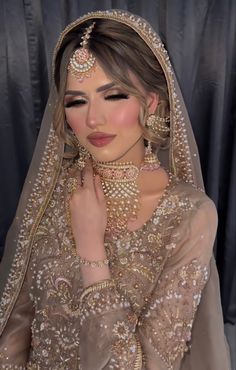 a woman wearing a bridal veil and jewelry