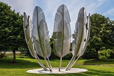 three metal sculptures in the middle of a park