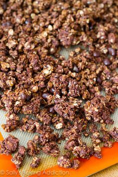 chocolate granola on an orange cutting board