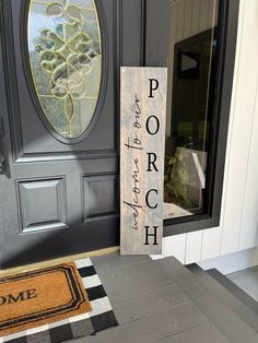 a porch sign sitting in front of a door with a welcome mat on the floor