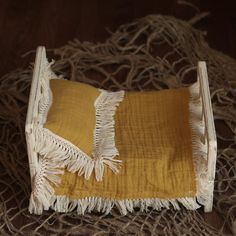 a yellow and white blanket laying on top of a wooden floor