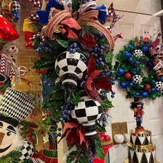 christmas wreaths and ornaments are hanging on the wall in front of a door with red, white and blue decorations