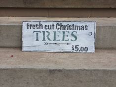 a sign that says fresh cut christmas trees on the side of some concrete step steps