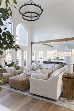 a living room filled with furniture and a chandelier hanging over the top of it