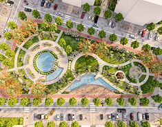 an aerial view of a parking lot with cars parked in it and trees on the other side