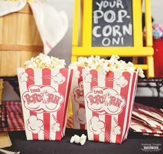 two red and white popcorn bags sitting on top of a table