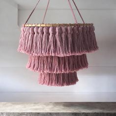 a pink chandelier hanging from the ceiling with fringes and gold trimming