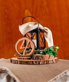 a wooden table topped with a candle holder and a ribbon tied around it's top