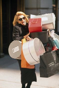 a woman walking down the street carrying shopping bags