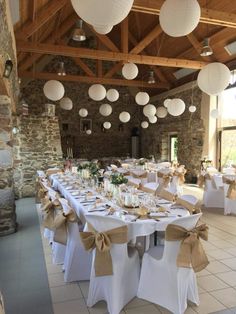 tables are set up with white linens and paper lanterns