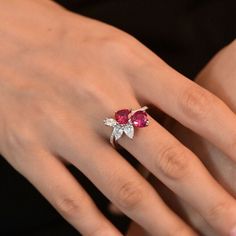 a woman's hand wearing a ring with three stones