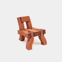 a wooden chair made out of bricks on a white surface with no one around it