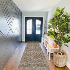 a long hallway with a plant on the floor and a blue door in the background