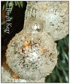 two silver ornaments hanging from a christmas tree