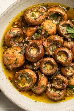 a white bowl filled with mushrooms and herbs