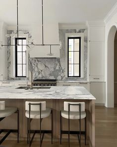 a kitchen with marble counter tops and stools