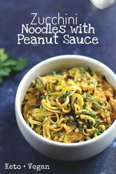 zucchini noodles with peanut sauce in a white bowl on a blue countertop