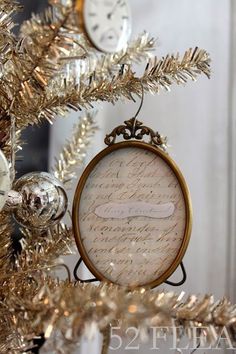 a christmas tree decorated with gold tinsel and white ornaments, including an ornament