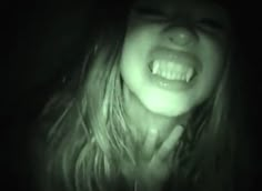 a woman with her mouth open in the dark