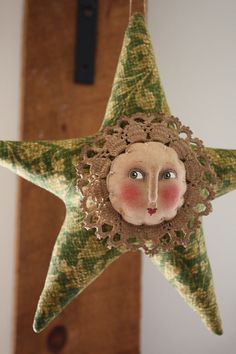 a green and white star with a face on it's side hanging from a hook