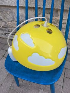 a yellow and blue chair with clouds painted on it