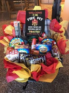 a basket filled with food and candy on top of a carpeted floor next to a sign