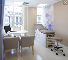 a hospital room with chairs, desks and a laptop on the table in front of a window