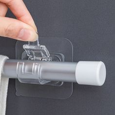 a person is holding a piece of clear plastic with a clip on the side of it