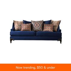 a blue couch with colorful pillows on it's back and sides, against a white background