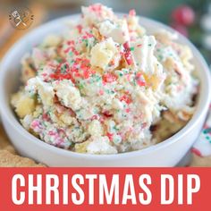 a bowl full of christmas dip with sprinkles and candy canels on top