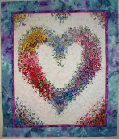 a heart shaped quilt hanging on the wall